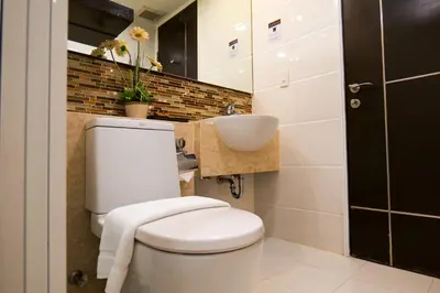 a bathroom with a white toilet and a sink at The Prestige Nana in Bangkok