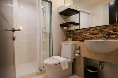 a bathroom with a toilet and a sink and a shower at The Prestige Nana in Bangkok