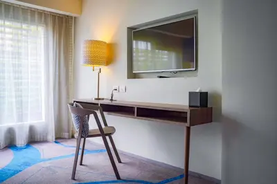 a desk with a television and a chair in a room at Tinidee Trendy Bangkok Khaosan in Bangkok