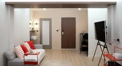 a living room with a white couch and a television at Theme Stories - Boutique Guesthouse in Bangkok