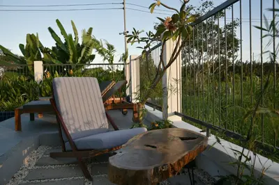 a chair and a coffee table on a patio at Green Lung Pool Villas Bangkok in Bang Krasop
