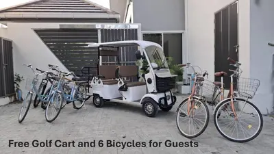 a golf cart with bikes parked next to a building at Green Lung Pool Villas Bangkok in Bang Krasop