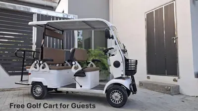 a white golf cart parked next to a building at Green Lung Pool Villas Bangkok in Bang Krasop