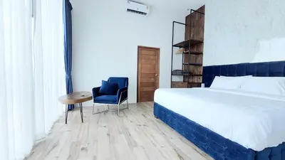 a bedroom with a bed and a chair and a table at Green Lung Pool Villas Bangkok in Bang Krasop