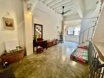 a living room with a staircase and a mirror at Baan KhaoSoi - Private room in a rooftop hostel 2nd floor in Khlong San