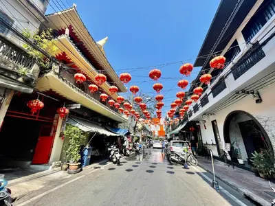 a street with red lanterns hanging from buildings at Baan KhaoSoi - Private room in a rooftop hostel 2nd floor in Khlong San