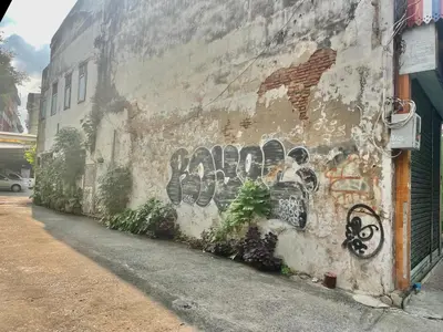 a wall with graffiti on the side of a building at Baan KhaoSoi - Private room in a rooftop hostel 2nd floor in Khlong San