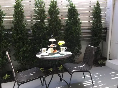 a table with two chairs and a table with food on it at Marigold Ramkhamhaeng in Bangkok
