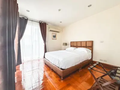a bedroom with a bed and a large window at Chez Moi Bangkok Private Executive Residence Sukhumvit 26 in Khlong Toei