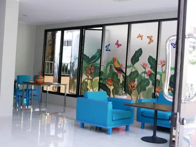 a room with tables and blue chairs and windows at ศิวพฤกษ์ เพลส in Nonthaburi