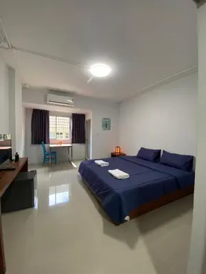 a bedroom with a large blue bed and a desk at ศิวพฤกษ์ เพลส in Nonthaburi