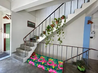 a room with stairs with a pillow and flowers at Baan KhaoSoi - Private room in a rooftop hostel 3rd floor in Khlong San