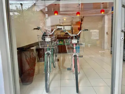 two bikes parked in a window of a store at Baan KhaoSoi - Private room in a rooftop hostel 3rd floor in Khlong San