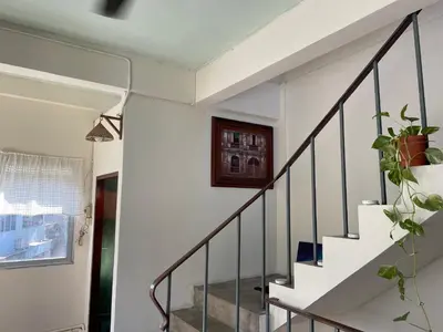 a staircase in a house with a potted plant at Baan KhaoSoi - Private room in a rooftop hostel 4th floor in Khlong San