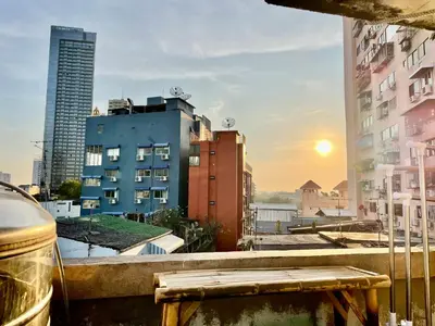 a view from a balcony of a city with buildings at Baan KhaoSoi - Private room in a rooftop hostel 4th floor in Khlong San