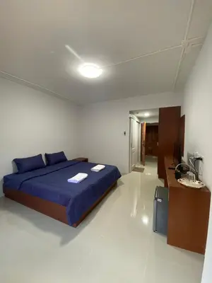 a bedroom with a blue bed and a desk at ศิวพฤกษ์ เพลส in Nonthaburi