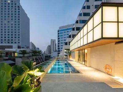 a pool in the middle of a building with tall buildings at Sotetsu Grand Fresa Bangkok in Bangkok