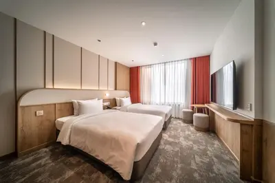 a hotel room with two beds and a television at Sotetsu Grand Fresa Bangkok in Bangkok