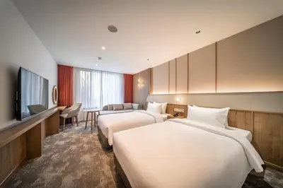 a hotel room with two beds and a television at Sotetsu Grand Fresa Bangkok in Bangkok