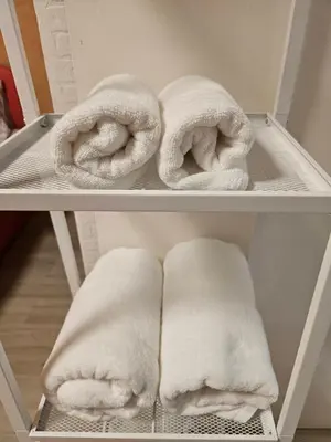 two white towels on a shelf in a closet at Hommie by De-A-Ga in Ban Bang Talat