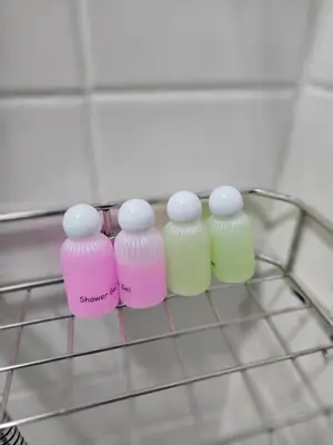 a wire rack with four different colored bottles on it at Hommie by De-A-Ga in Ban Bang Talat