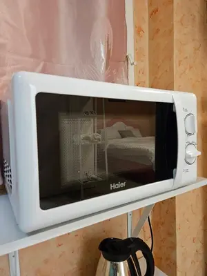 a white microwave oven sitting on a shelf at Hommie by De-A-Ga in Ban Bang Talat