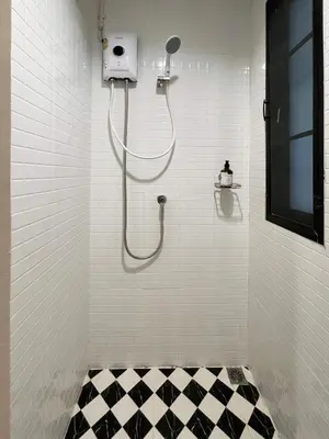 a bathroom with a shower with a black and white floor at Rema residence China town Main Road in Bangkok