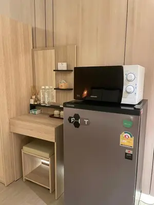 a small refrigerator with a microwave on top of it at Rema residence China town Main Road in Bangkok
