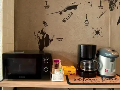 a microwave sitting on a table next to a coffee maker at 829 Backpack Bangkok BM B&B in Bangkok