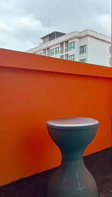 a green toilet sitting next to an orange fence at 829 Backpack Bangkok BM B&B in Bangkok