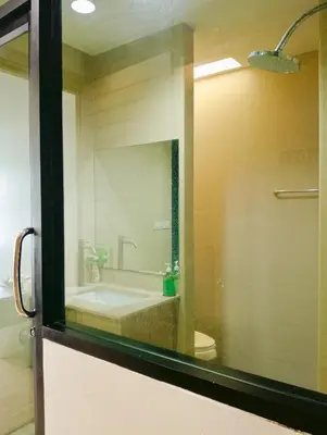 a bathroom with a sink and a toilet and a mirror at Travel Bangkok BM B&B in Bangkok