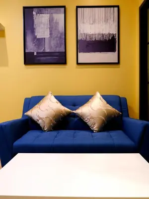 a blue couch with two pillows in a living room at BEB Silom Condolette in Bangkok