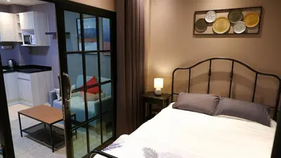 a bedroom with a bed and a chair in a room at BEB Silom Condolette in Bangkok