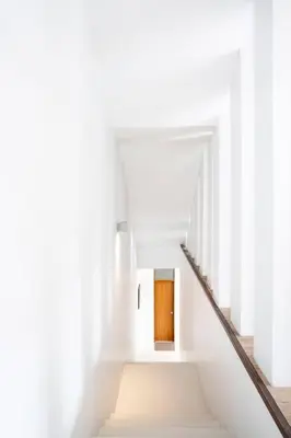 a staircase in a white building with a wooden door at Bangkok Luxury Pool Villa Thonglor in Bangkok