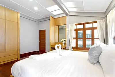 two swans sitting on a bed in a room at Sathorn Private Pool Villa in Bangkok