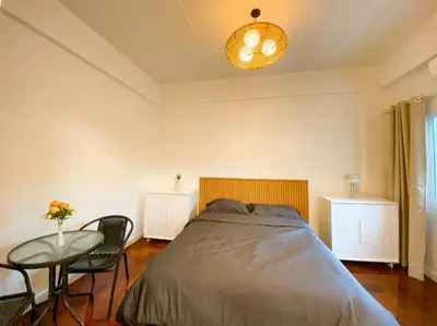 a bedroom with a bed and a table with chairs at Huge Living Room + 5 bedrooms with Private baths in Bangkok