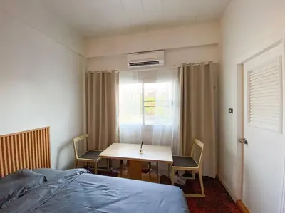 a bedroom with a table and chairs and a bed at Huge Living Room + 5 bedrooms with Private baths in Bangkok