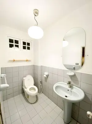 a bathroom with a toilet and a sink and a mirror at Huge Living Room + 5 bedrooms with Private baths in Bangkok