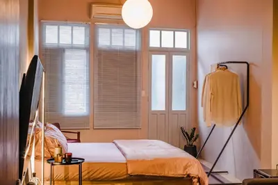 a bedroom with a bed in a room with a window at Cozy Room at The Coffee Store Charoenkrung in Bangkok