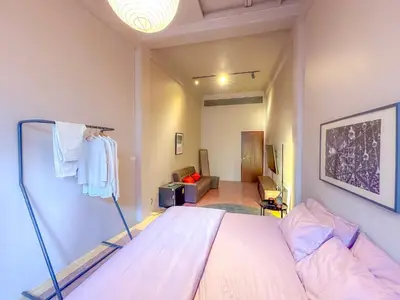 a bedroom with a bed and a living room at Cozy Room at The Coffee Store Charoenkrung in Bangkok