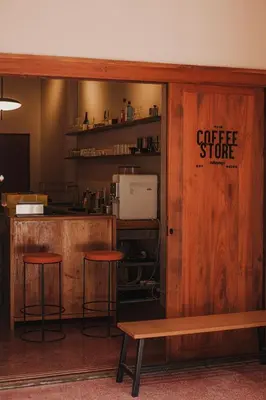 a coffee store with two stools and a bench at Cozy Room at The Coffee Store Charoenkrung in Bangkok