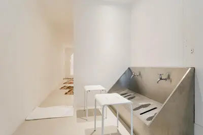 a white room with two tables and a staircase at Thomson Hotel Huamark in Bangkok