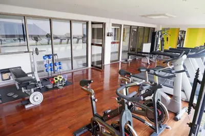 a gym with several treadmills and cardio machines at Thomson Hotel Huamark in Bangkok