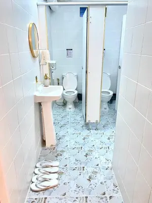 a bathroom with two toilets and a sink at Guesthouse Station in Bangkok