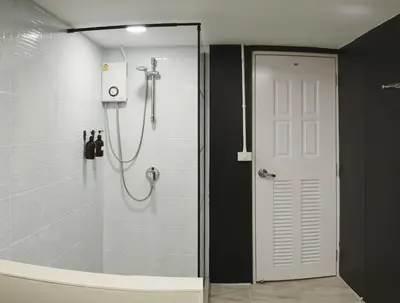 a shower with a glass door in a bathroom at Hidden Gems in China town, 2BR in Bangkok