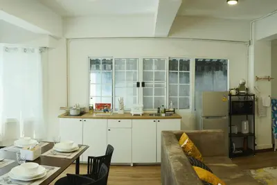 a living room with a couch and a table and a kitchen at Hidden Gems in China town, 2BR in Bangkok