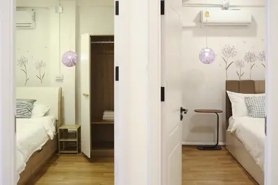 a room with two beds and a bedroom with purple pendants at 3BR in China Town, Rare to find 2 mins from MRT train in Bangkok