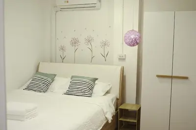 a bedroom with a white bed with two pillows at 3BR in China Town, Rare to find 2 mins from MRT train in Bangkok