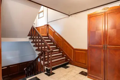 a staircase in a building with wooden railings at 23 AVA at Saladaeng in Bangkok