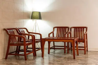 three wooden chairs and a table with a lamp at 23 AVA at Saladaeng in Bangkok